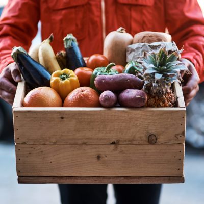 Delivered fresh right to your door. Cropped shot of a man delivering a crate full of fruit and vegetables. Cropped shot of a man delivering a crate full of fruit and vegetables.